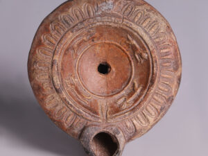 ancient roman terracotta oil lamp with rabbits and dogs